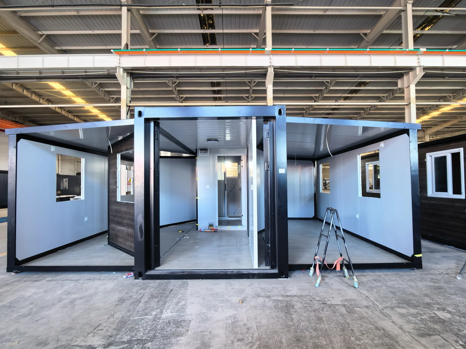 Expandable house sample with open side sections during assembly