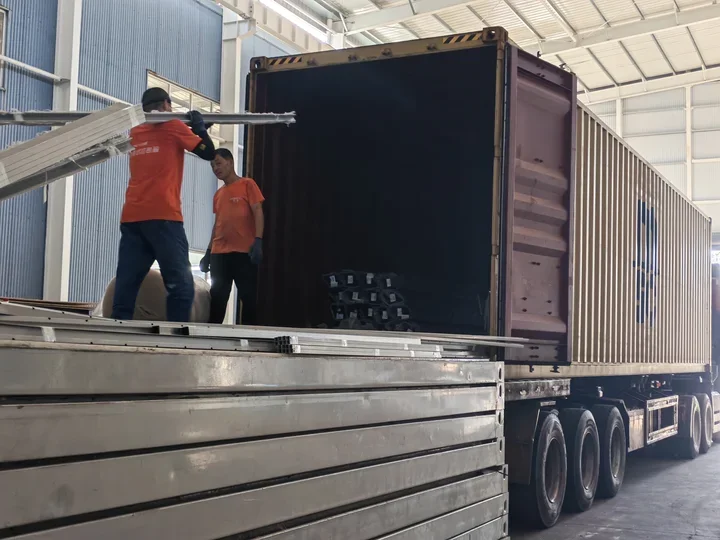 Workers loading components into a shipping container